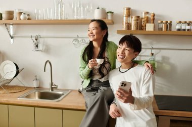 Genç bir çift kahvaltıdan zevk alır, gülümsemelerini ve kahvelerini paylaşırlar..