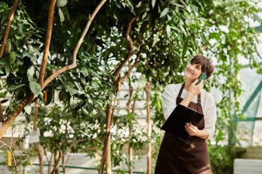 Olgun bir kadın, canlı bir serada çalışmaktan zevk alır. Doğayla ve müşterilerle bağ kurar..