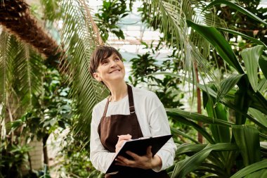 Etrafı canlı yeşilliklerle çevriliyken olgun bir kadın hevesle görevlerini yerine getiriyor.
