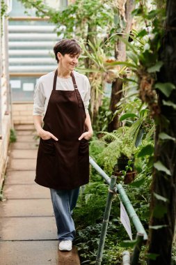 Sera ortamında kendine güveni tam bir kadın yemyeşil bitkilerle ilgileniyor..