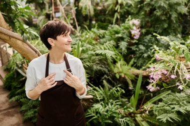 Huzurlu bir serada, kendine güvenen bir kadın canlı bitkiler ve çiçekler arasındaki işinden zevk alır..