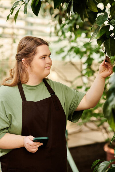 In a greenhouse, a confident young woman with Down syndrome nurtures thriving plants.