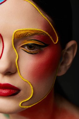 Benzersiz yüz sanatına sahip çarpıcı genç bir kadın canlı ve şık makyajını yakından gösteriyor..