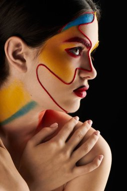 Genç bir kadın çarpıcı yüz sanatını cesur renklerle sergiliyor ve güzelliğini artıran tanımlanmış çizgiler sergiliyor..