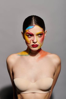 Genç ve güzel bir kadın yaratıcı bir sanat oturumu sırasında çarpıcı yüzünü canlı renklerle sergiliyor..