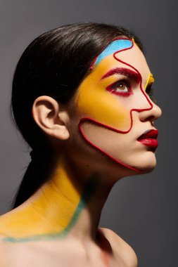 Genç ve güzel bir kadın canlı renklerle ve zarif makyajla çarpıcı bir yüz sanatı sergiliyor..