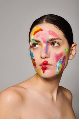 Genç bir kadın canlı yüz sanatı sergiliyor, renkleri şık bir şekilde harmanlıyor..