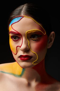 Genç bir kadın çarpıcı yüz sanatını canlı, göz alıcı soyut tasarımlarıyla sergiliyor..