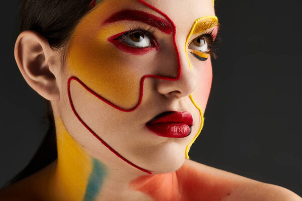 Смелые, яркие цвета и рисунки на лице молодой женщины делают поразительное заявление.
