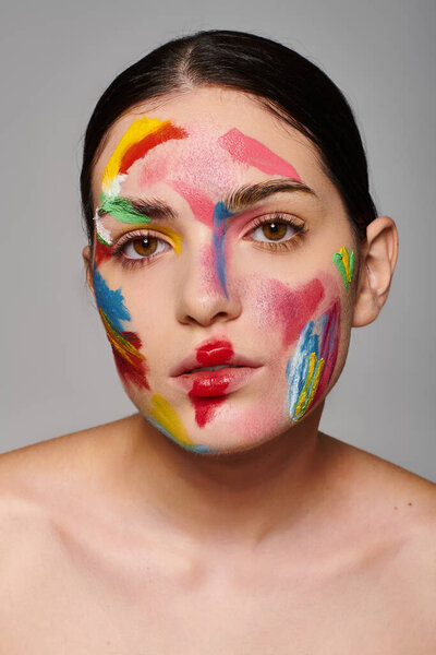 Молодая женщина демонстрирует потрясающее искусство лица с яркими красками, которые подчеркивают ее красоту и стиль.
