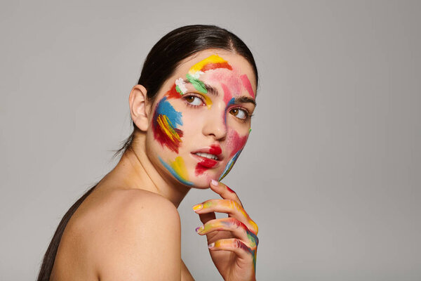 Живая молодая женщина с краской для лица позирует стильно, демонстрируя творчество и красоту..
