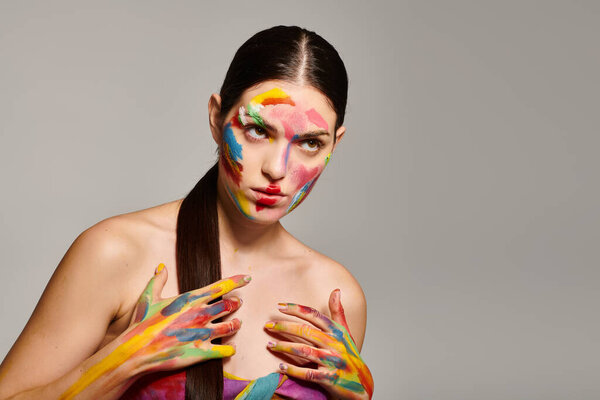 Молодая женщина демонстрирует яркое лицо в творческой фотосессии.