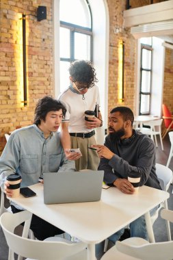 Üç iş arkadaşı şık bir masada birlikte çalışırken odaklanmış bir tartışmaya giriştiler..
