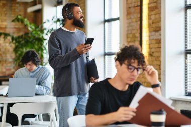 Genç profesyoneller teknolojiyi parlak, yeşil ve havadar bir ofis alanında kullanıyorlar..