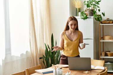 Genç bir kadın, modern çalışma odasında canlı canlı sohbet ederken elinde kahve fincanı tutuyor..