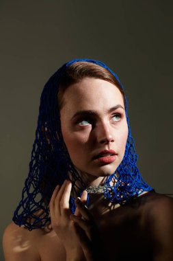 Detaylar, mavi başlıklı güzel bir kadının zarif cazibesinin altını çiziyor..