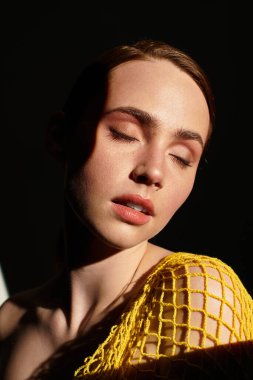 Huzurlu genç bir kadın, güneş ışığının hafifçe yüzünü aydınlatmasıyla rahatlar..