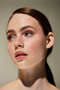 Genç, güzel bir kadın düşünceli bir şekilde yan tarafa bakıyor, doğal zarafet ve duruş sergiliyor..