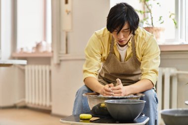 Canlı bir çömlek stüdyosunda, bir sanatçı kil kalıplarını özenle şekillendirir, tekerlek üzerinde benzersiz yaratımlar oluşturur..