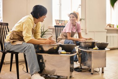 Parlak bir çömlek atölyesinde, birkaç kalıp birlikte, yaratıcılık ve bağlantı sergiliyorlar..