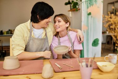 Genç bir çift, hoş geldin stüdyo atmosferinde çömlekçilik yapıyor..