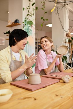 Neşeli genç çift birlikte çömlek yapmayı, stüdyoda yaratıcılığı ve romantizmi kucaklamayı seviyor..