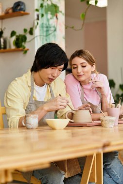 Bir çift, ilham kaynağıyla dolu samimi bir sanat stüdyosundaki çömlekçilik projesinde zevkle işbirliği yapıyor..