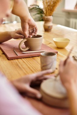 Genç çift, rahat ve yaratıcı bir sanat stüdyosunda mutlu mesut çömlek yapıyorlar..