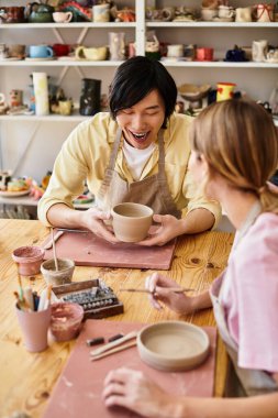 Bir çift sıcak, sanatsal bir stüdyoda çömlek şekillendiriyor..