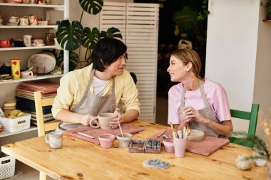 Genç bir çift birlikte kil şekillendirir, sanatsal araçlar ve dekorasyonlar arasında kaliteli zaman geçirirler..