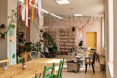 Renkli sanatın, bitkilerin ve yaratıcıların hoş geldin atmosferinin yer aldığı parlak çömlek stüdyosu.