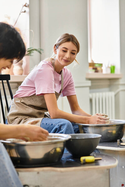A couple engages in pottery creation, sharing smiles and love while shaping clay at the studio.