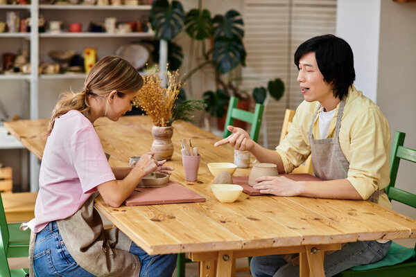 Young couple enjoys a creative pottery session in a welcoming art studio filled with natural light.