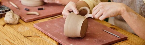 Hands skillfully shape and refine clay into beautiful pottery in a brightly lit creative space.