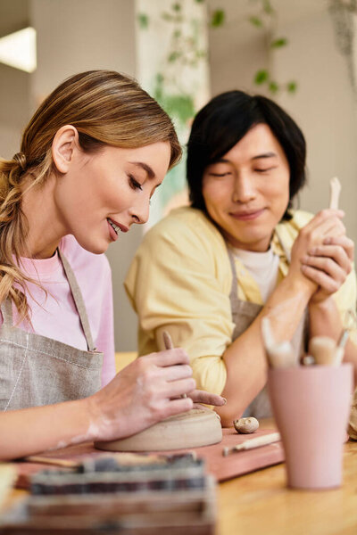 Молодая пара делает керамику вместе, создавая уникальные части наполненные улыбками и любовью.