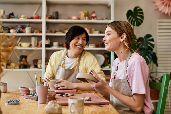 A young couple shares laughter and joy while working on pottery, connecting through art and love.