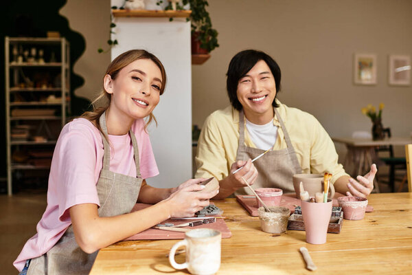 Молодая пара наслаждается изготовлением керамики в очаровательной студии, делясь смехом и творчеством.
