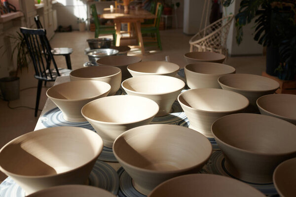 Clay elegant bowls in a bright and inviting pottery studio.