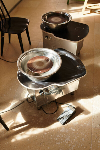 Two pottery wheels await the artists touch in a bright, inviting studio, ready for creation.