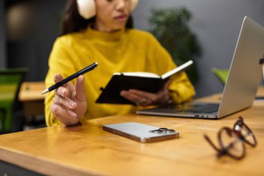 Şık giyinmiş güzel bir kadın ofis gereksinimleriyle çevriliyken görevlerine odaklanıyor..