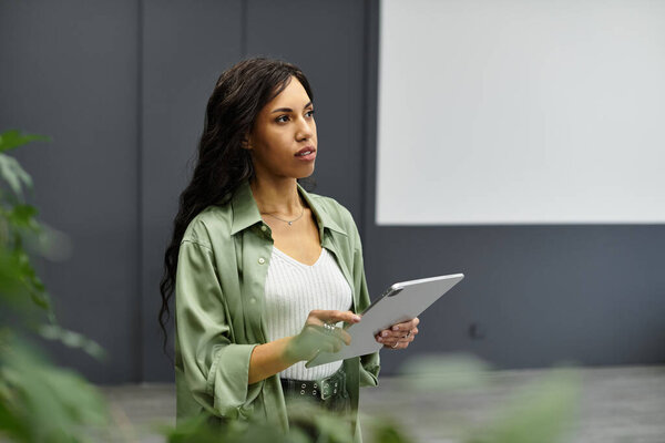 Young professional woman in an elegant outfit intently brainstorms on her digital tablet.