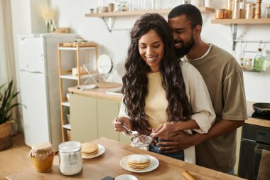 Mutlu bir çift, sıcak mutfaklarında birlikte krep yapar..