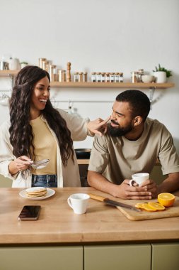 Mutlu bir çift, samimi mutfaklarında neşeli bir kahvaltı yapar..