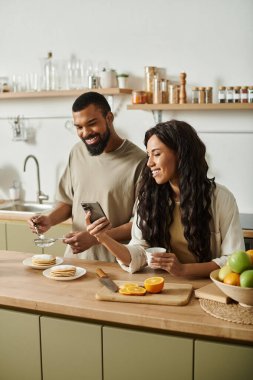 Neşeli bir Afrikalı Amerikalı çift evde kahvaltı hazırlarken kaliteli vakit geçiriyor..