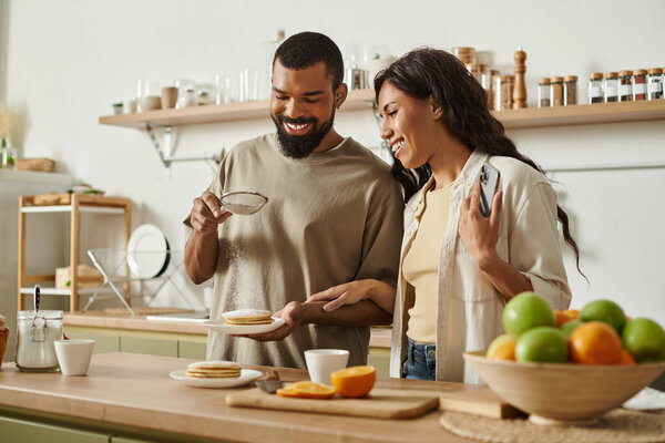 A joyful couple shares a special moment cooking a delightful breakfast together.