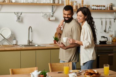 Mutlu bir çift, sıcak mutfaklarında kahveyi ve gülümsemeyi paylaşır..