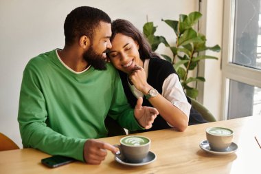 Afro-Amerikalı bir çift, güzel bir kafede içki yudumlarken birbirlerine eşlik etmekten zevk alır..
