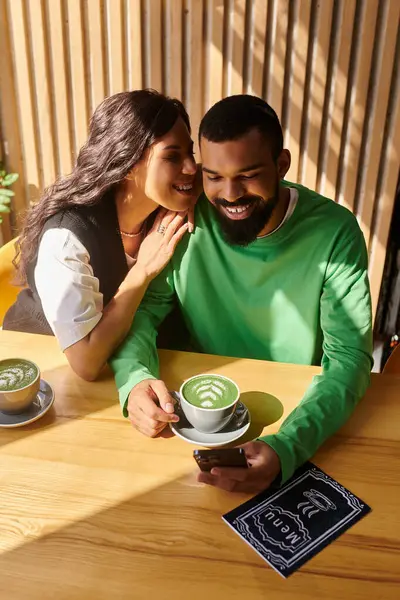 Afro-Amerikalı bir çift bir kafede içkilerini yudumlarken neşeli anları paylaşıyor..