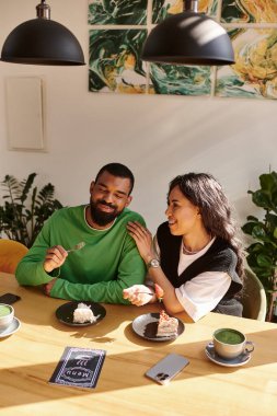 Afro-Amerikalı bir çift, kahkaha ve tatlıyı bir kafede paylaşıyor..