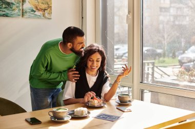 Afro-Amerikalı bir çift, bir kafede tatlıyı yerken birbirlerinin yanında olmaktan zevk alıyorlar..